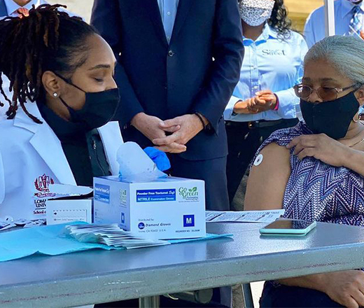 Doctor giving COVID-19 vaccine to elderly patient