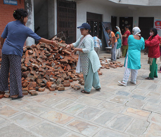 Woman handing each other bricks