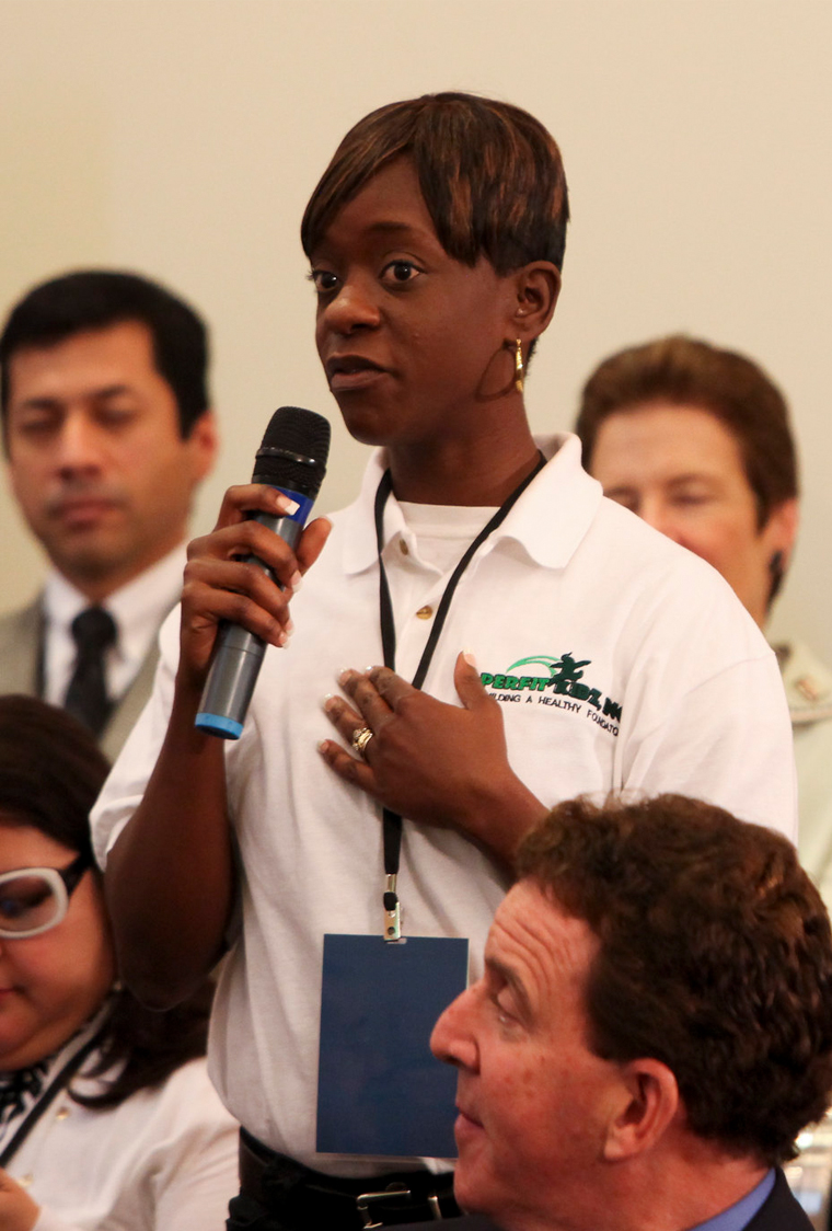 woman holding microphone in front of crowd