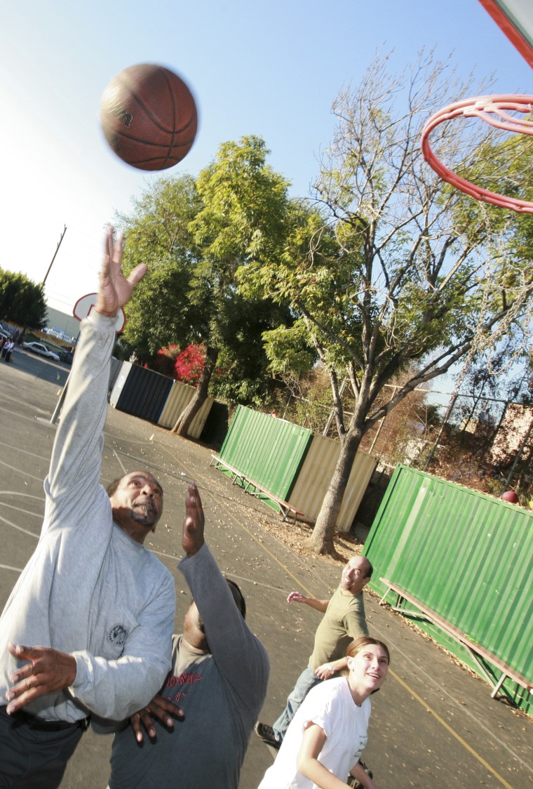 four people playing basketball