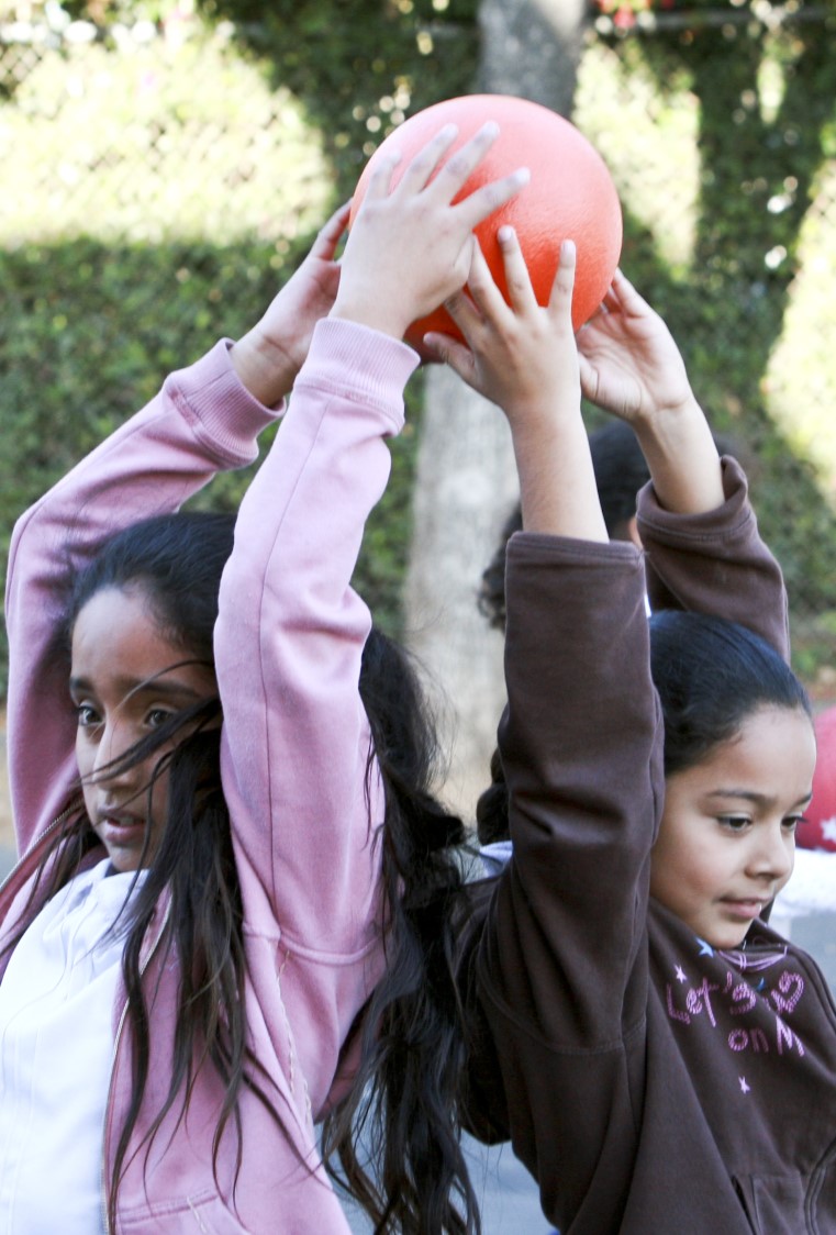 two young girls holding up ball