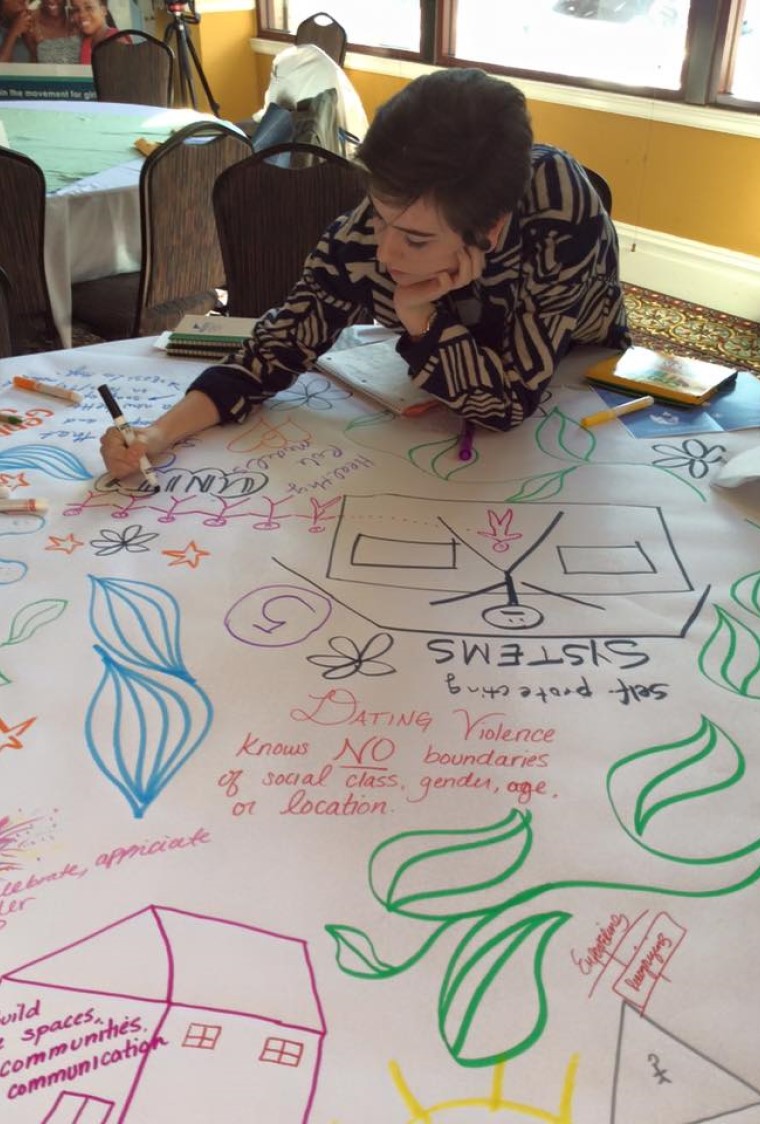 young woman creating a poster about domestic violence