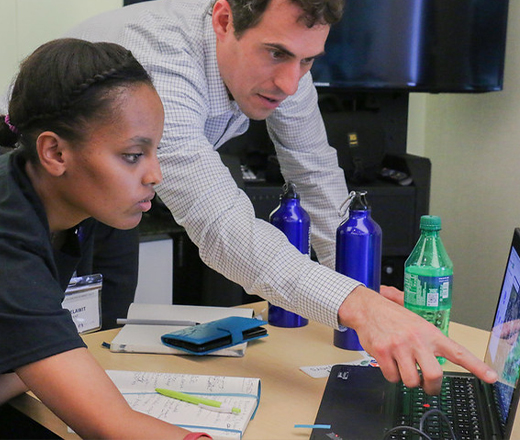 Man showing teen something on the computer