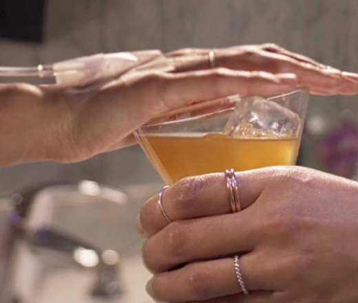 woman covering glass of alcohol