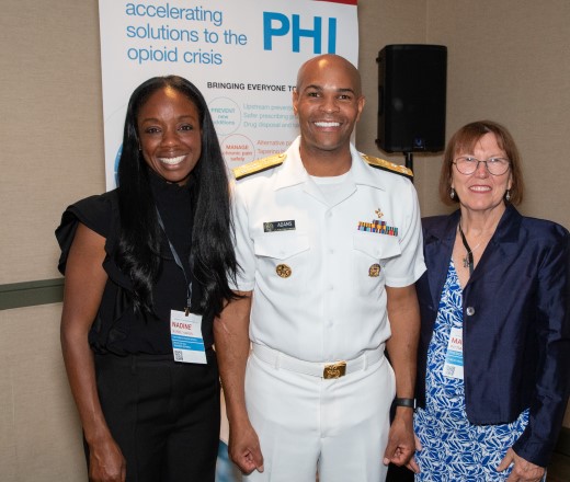 Nadine Burke Harris, Jerome Adams and Mary PIttman standing in front of a banner that says, PHI