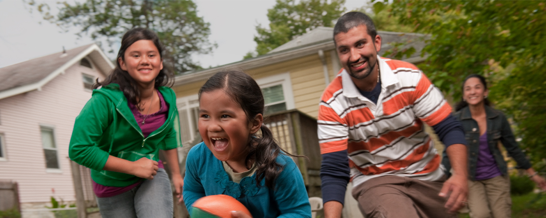 image: family playing football in backyard