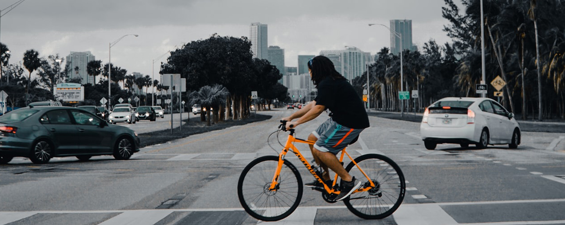 image: person riding bike in traffic with cars