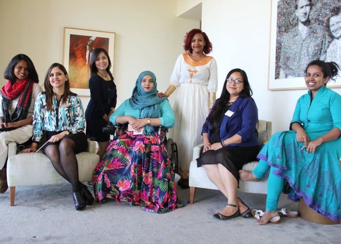 seven women sitting and standing, one woman in a wheelchair