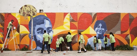 People standing in front of a colorful mural