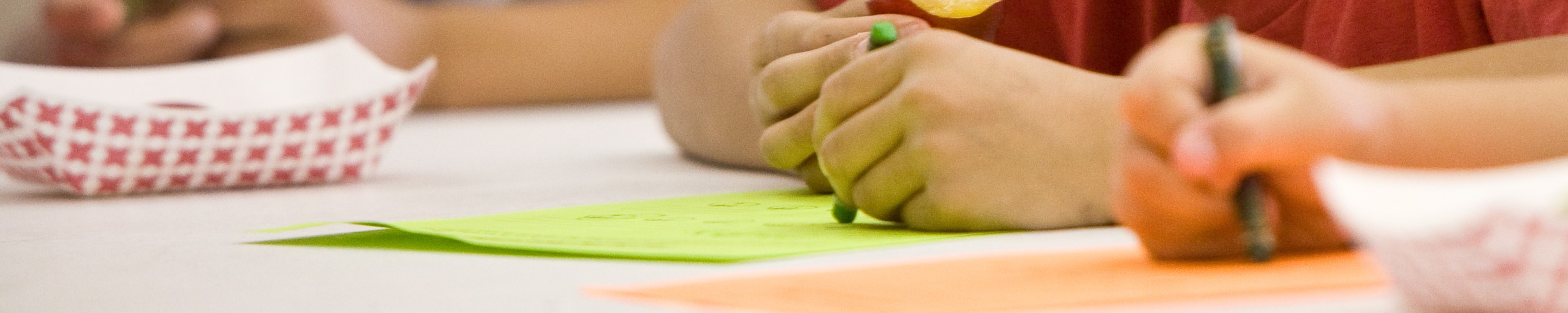 hands with crayons doing homework