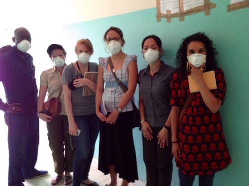 six people from the knees up, wearing ppe gear.