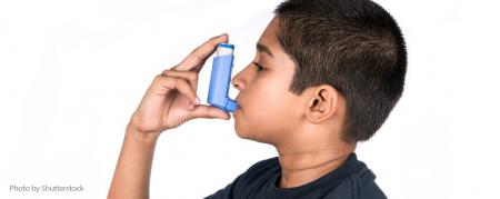 Child using an enhaler, white background