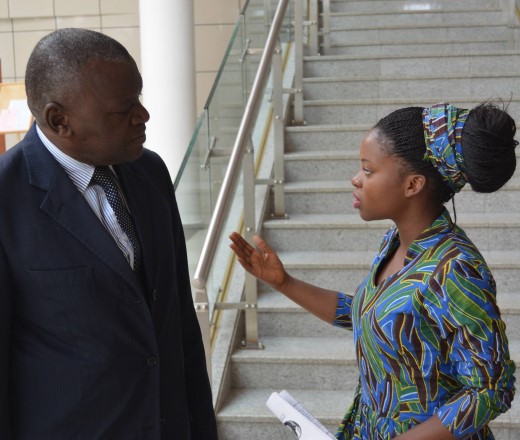 young woman speaking firmly to older man who is listening intently, she is gesturing to make a point