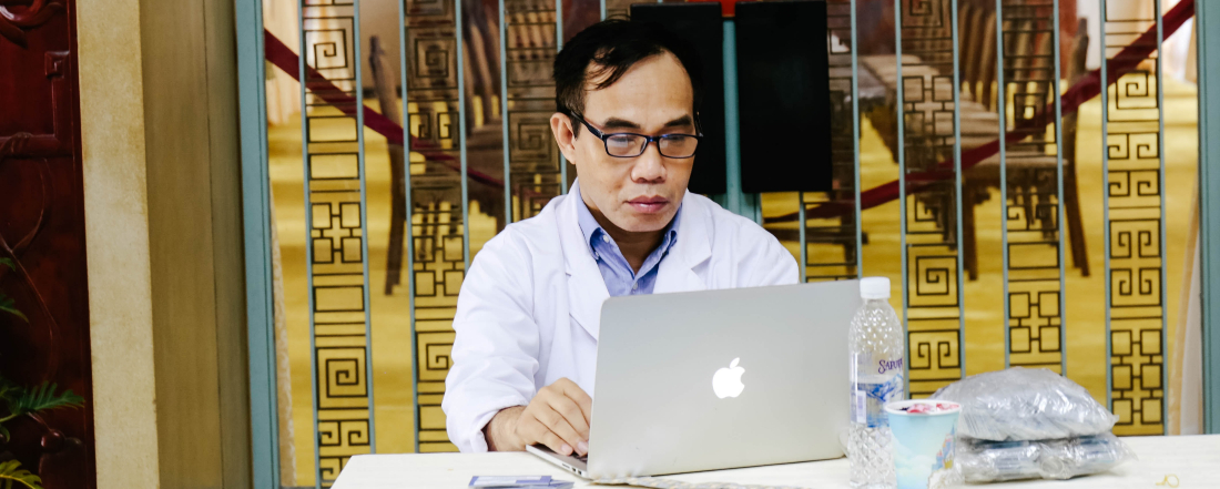 a doctor working at a laptop