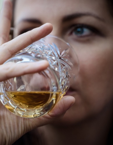 A woman drinking whiskey