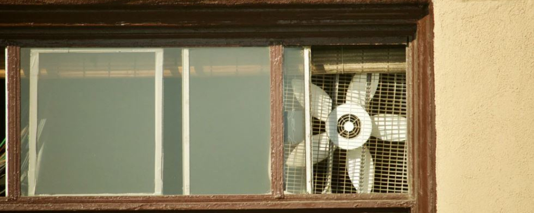 a window fan seen from outside an apartment window