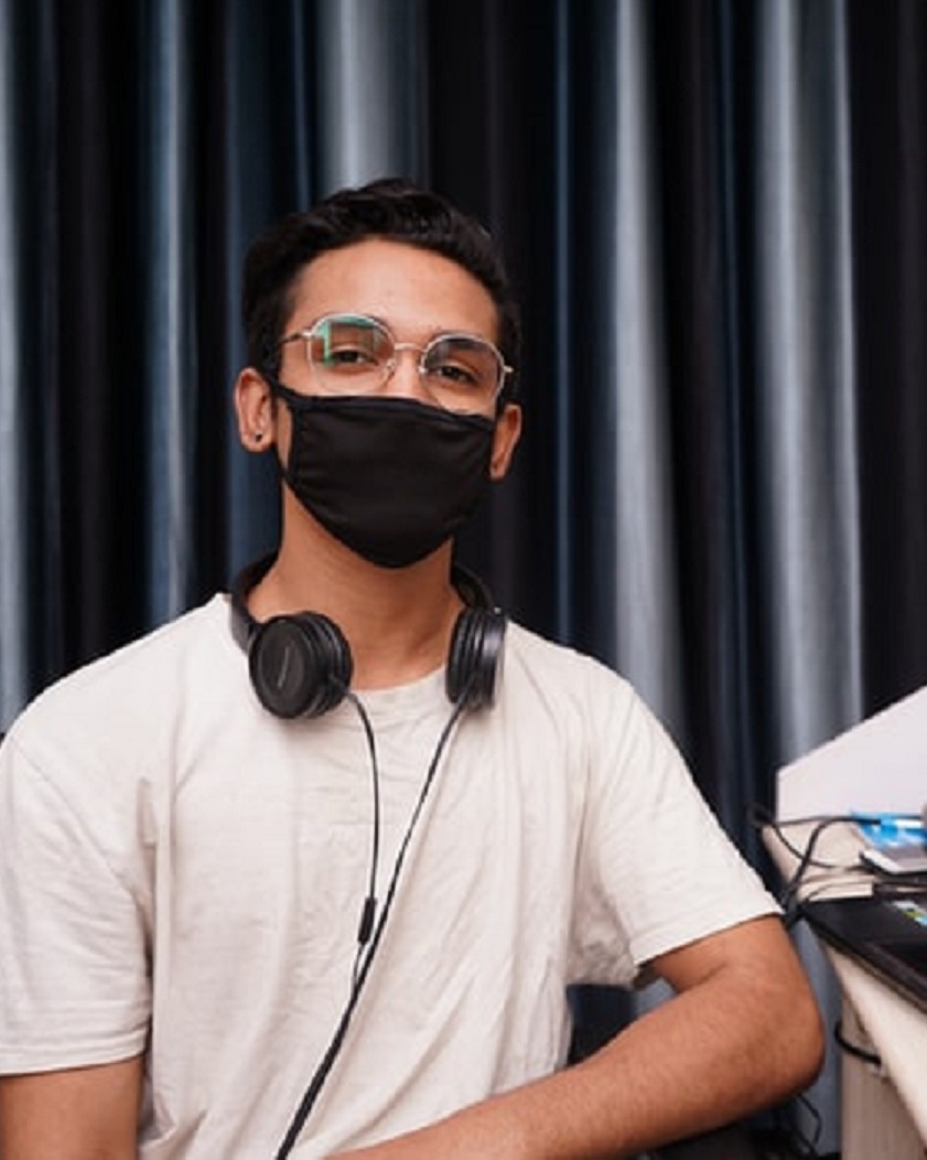 Man looking at camera, wearing a mask