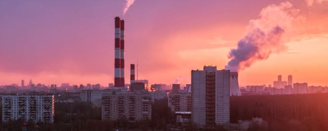 smokestacks billowing smoke over a city