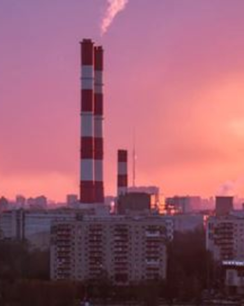 smokestacks billowing smoke over a city