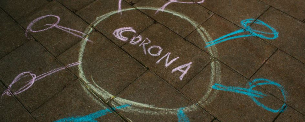 a chalk drawing of a circle with "corona" written in the center and smaller circles surround it