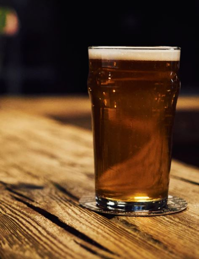 a glass of beer on a bar top