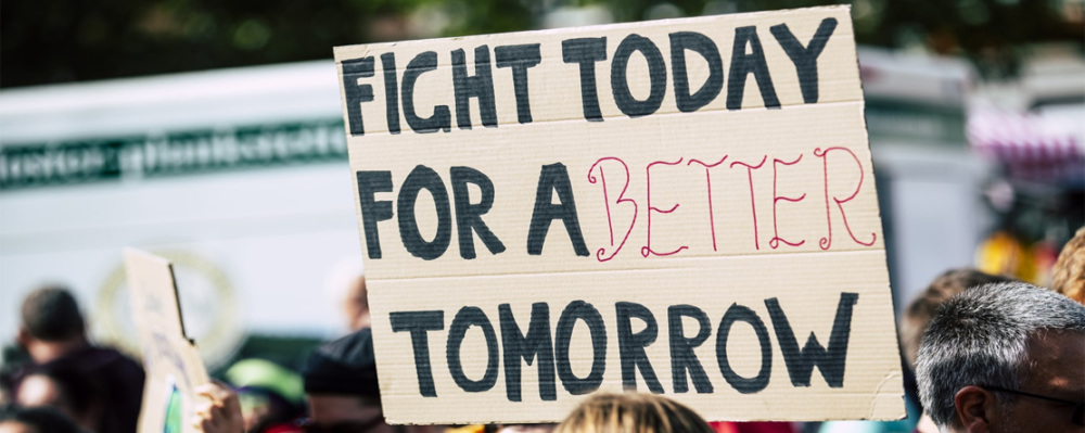 Protestors holding sign "Fight Today for a better tomorrow"