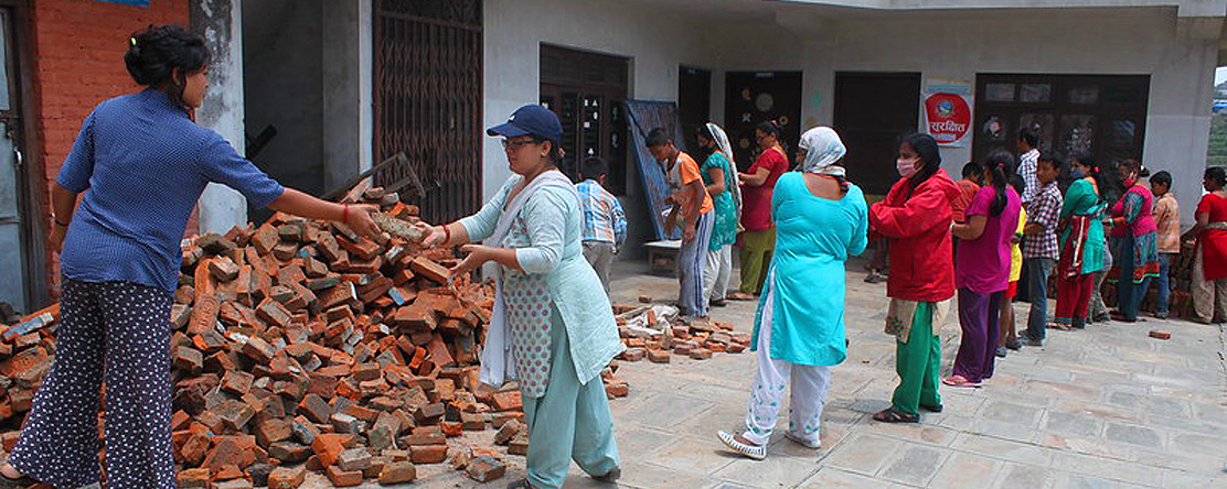 Group of people passing bricks to one another