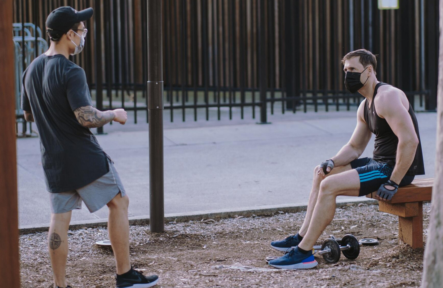 two men wearing face masks several feet apart
