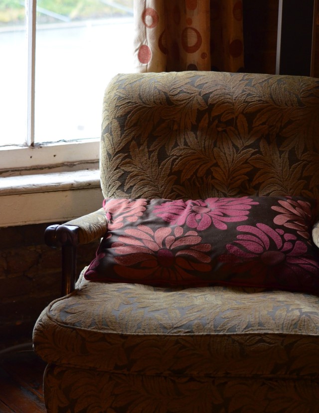 an empty chair sits near a window