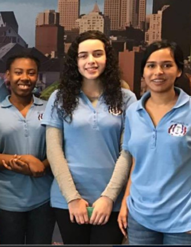 Three young women from FACES wearing FACES staff shirts