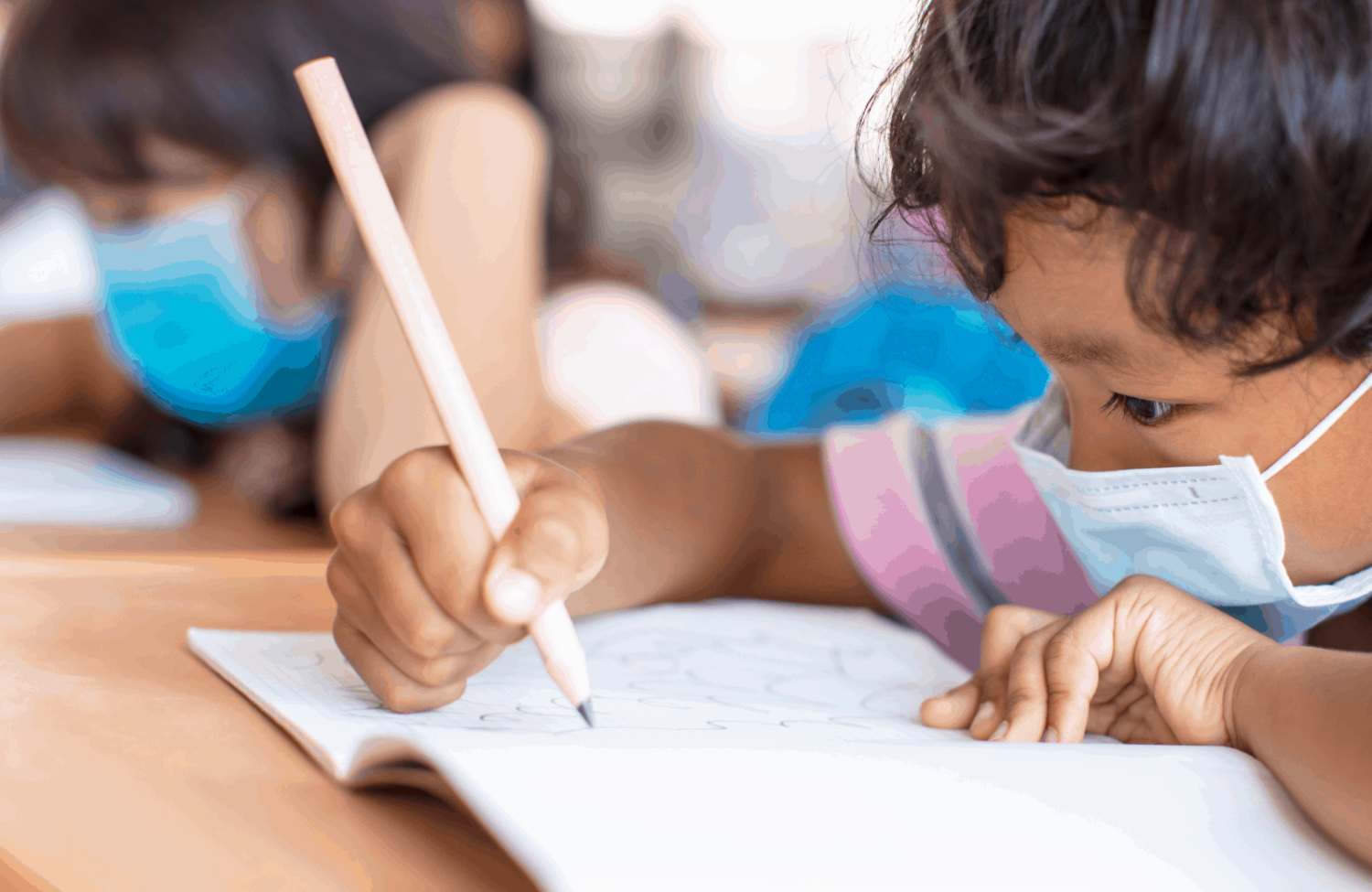 child writing wearing face mask