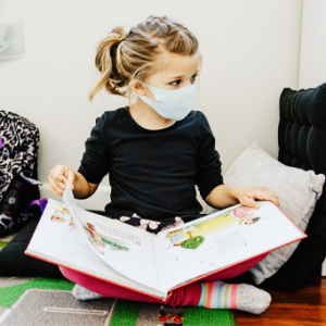 chils wearing mask reading book