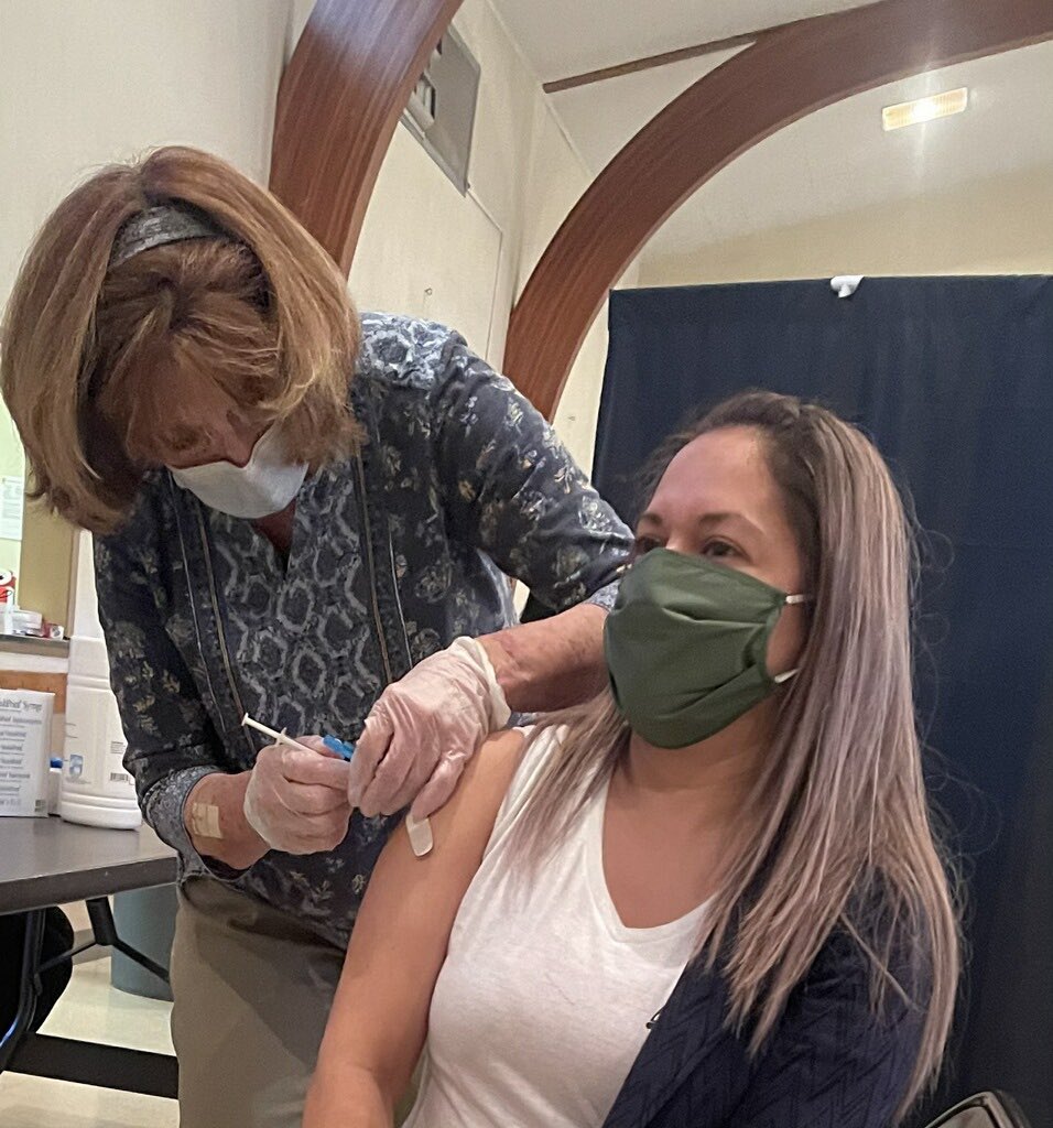 woman in chair receiving the COVID-19 vaccine