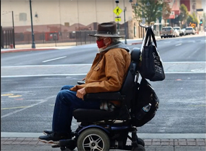 Man wearing mask in wheelchair