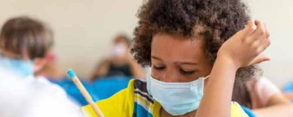 child working at school wearing a mask