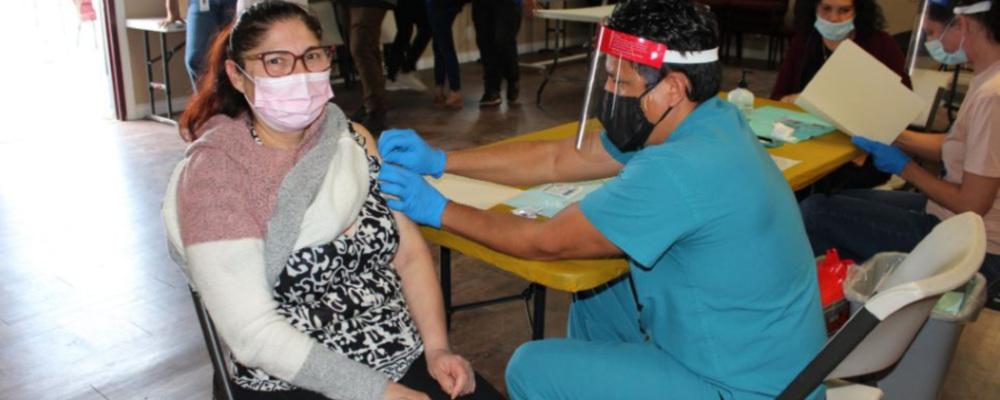 A doctor giving a shot to a patient at a pop-up vaccination clinic. Photo by Anna Almendrala / KHN