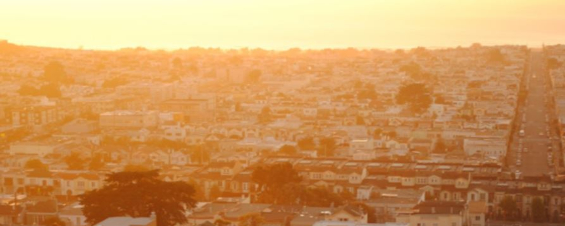 a hillside of homes on a very hazy, polluted day