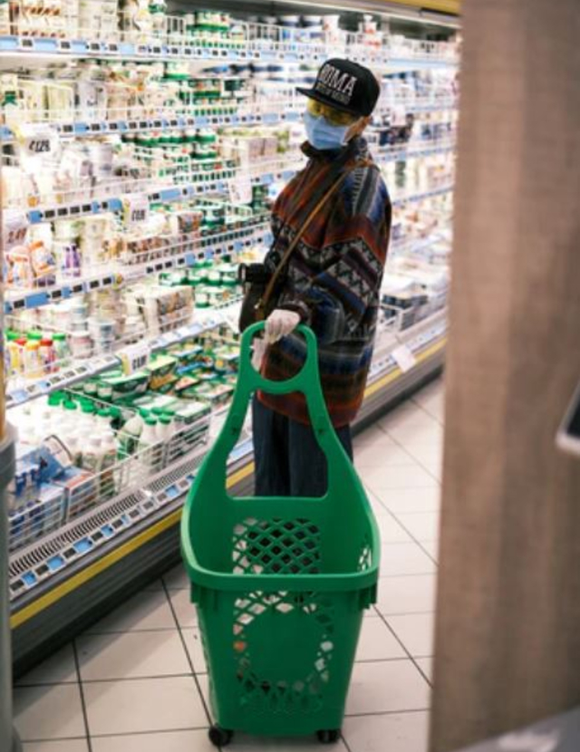 a man with a mask shopping in a grocery store