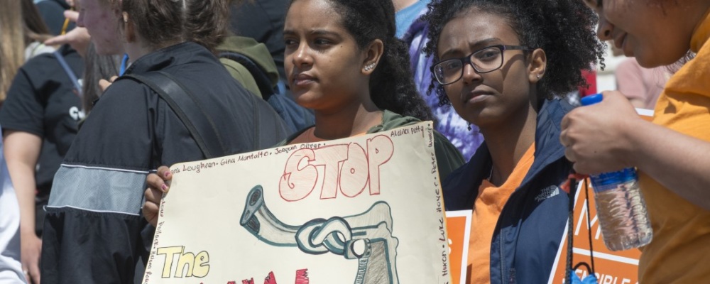 two girls holding a sign that says stop gun violence