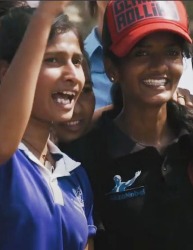 Two young women from Rise Up in India, one with her arm raised