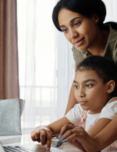 a Mom and child looking at a laptop