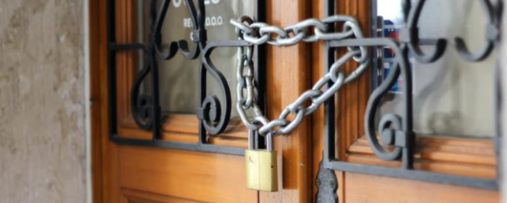 a wooden door locked with a heavy chain and padlock