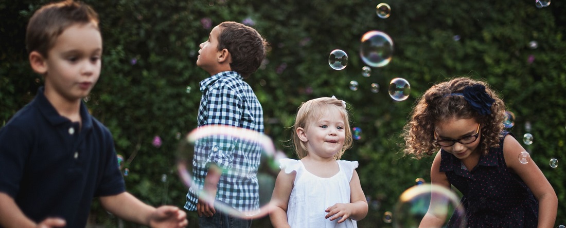 Children playing with bubbles outside