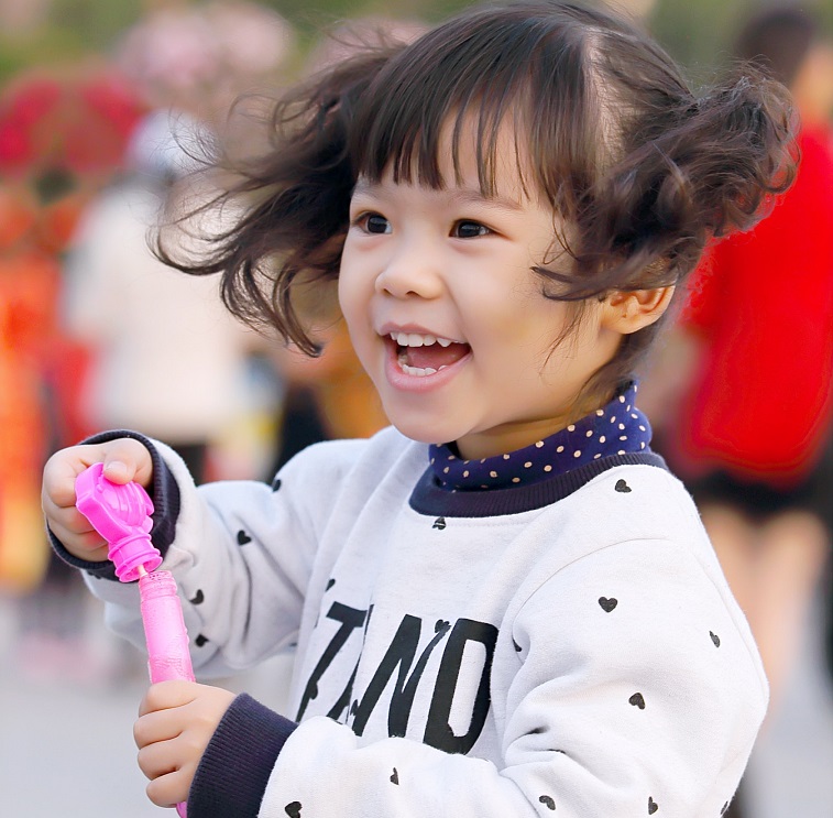 Girl, outside smiling and looking off camera