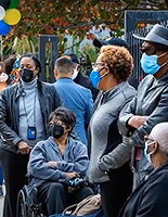 people standing in line wearing masks 