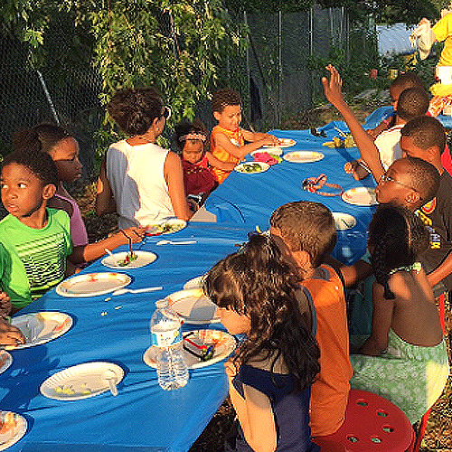 group of children sitting at a table eating