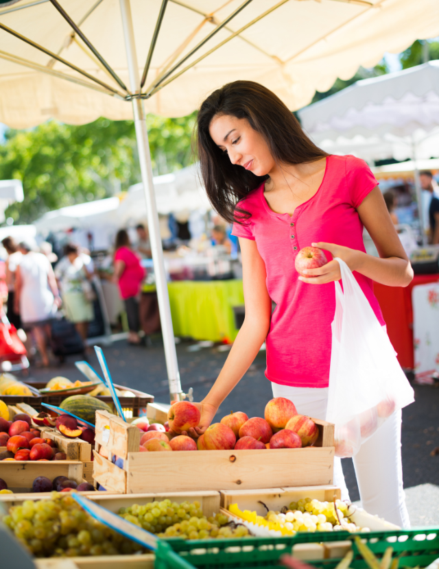 woman buying produce at a farmers market