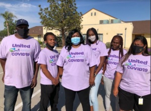 A group of five volunteers wearing United Against COVID t-shirts