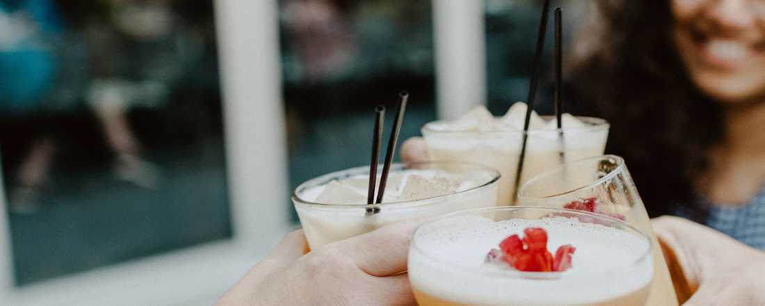 women bringing cocktail glasses together for a toast