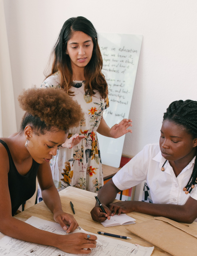 Three women of color at a workshop collaborating together